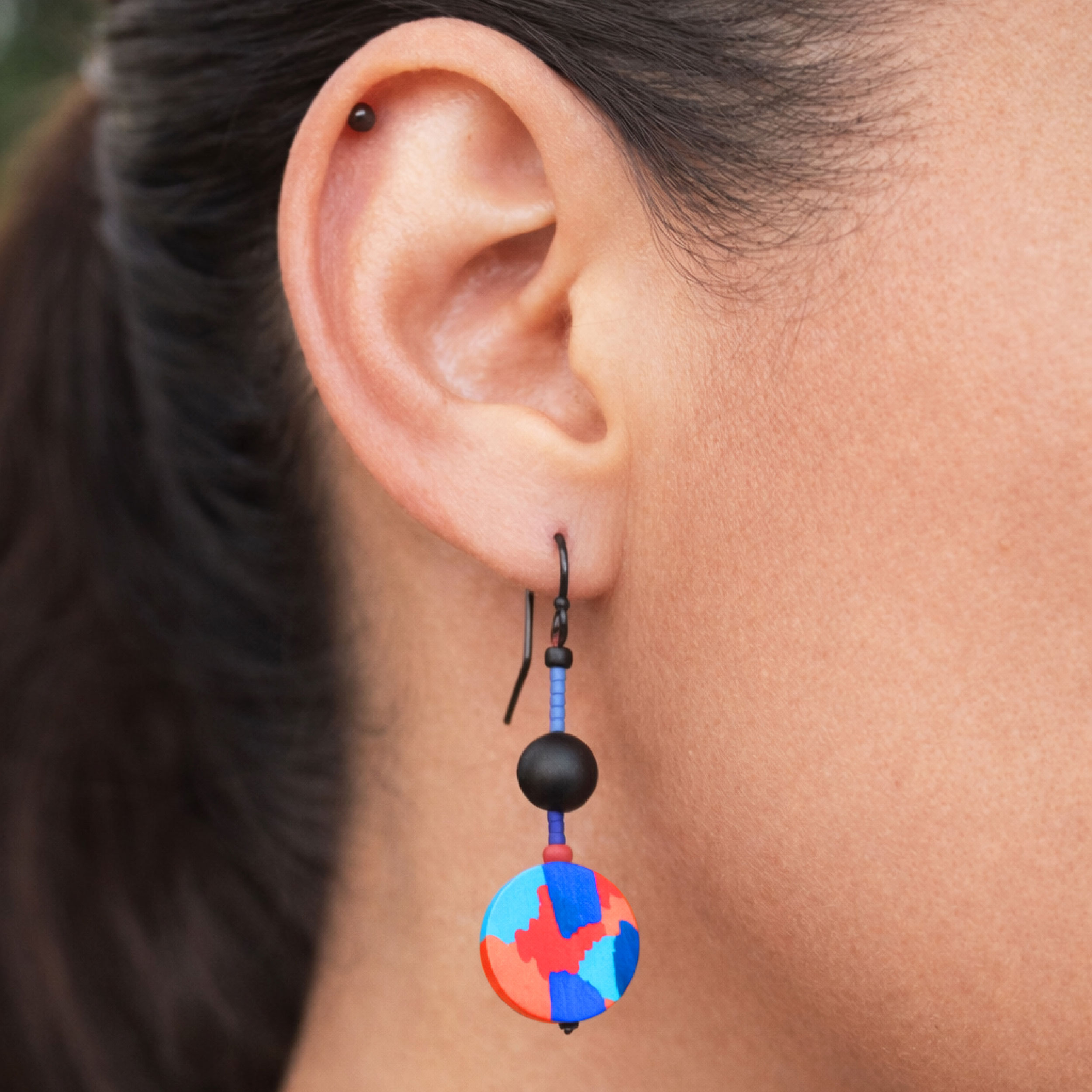 colorful mismatched earrings worn on ear geometric statement design